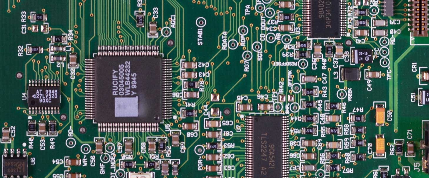 A close-up image of a circuit board showing microchips and various types of capacitors